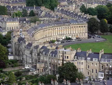 Aerial view of the curved Royal Crescent frontage, its green lawn and irregular backs of the Bath houses