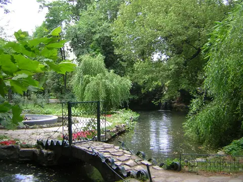 A planted bank, path and lake in Cișmigiu Gardens, Bucharest.