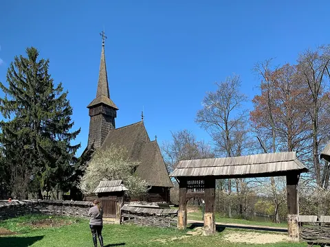 The steep shingled roof and timber walls of the Dragomirești church at Bucharest’s Village Museum