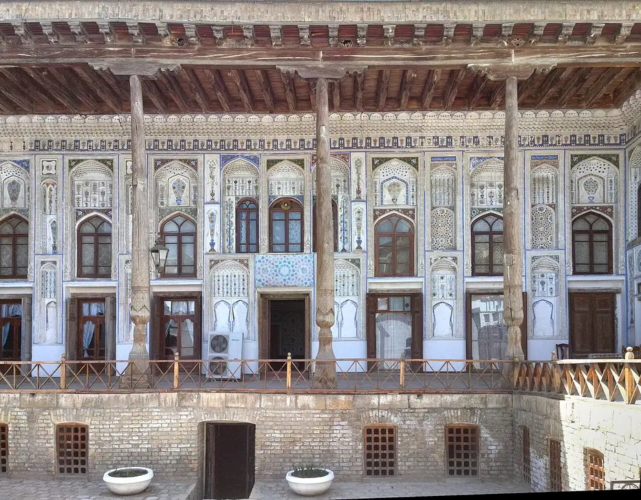 The carved wooden columns and decorated courtyard facade of the Fayzulla Khodjaev House Museum.