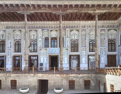The carved wooden columns and decorated courtyard facade of the Fayzulla Khodjaev House Museum.