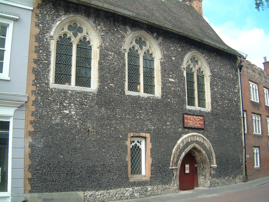 The flint frontage and arched street doorway of Eastbridge Hospital in Canterbury
