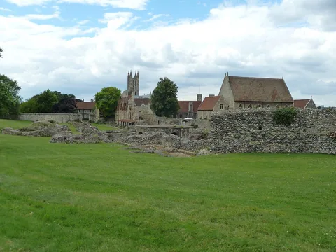Low stone remains at St Augustine’s Abbey with later buildings beyond the ruins