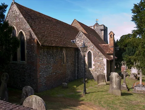 St Martin’s Church, Canterbury, with tiled roof, mixed masonry walls and churchyard gravestones