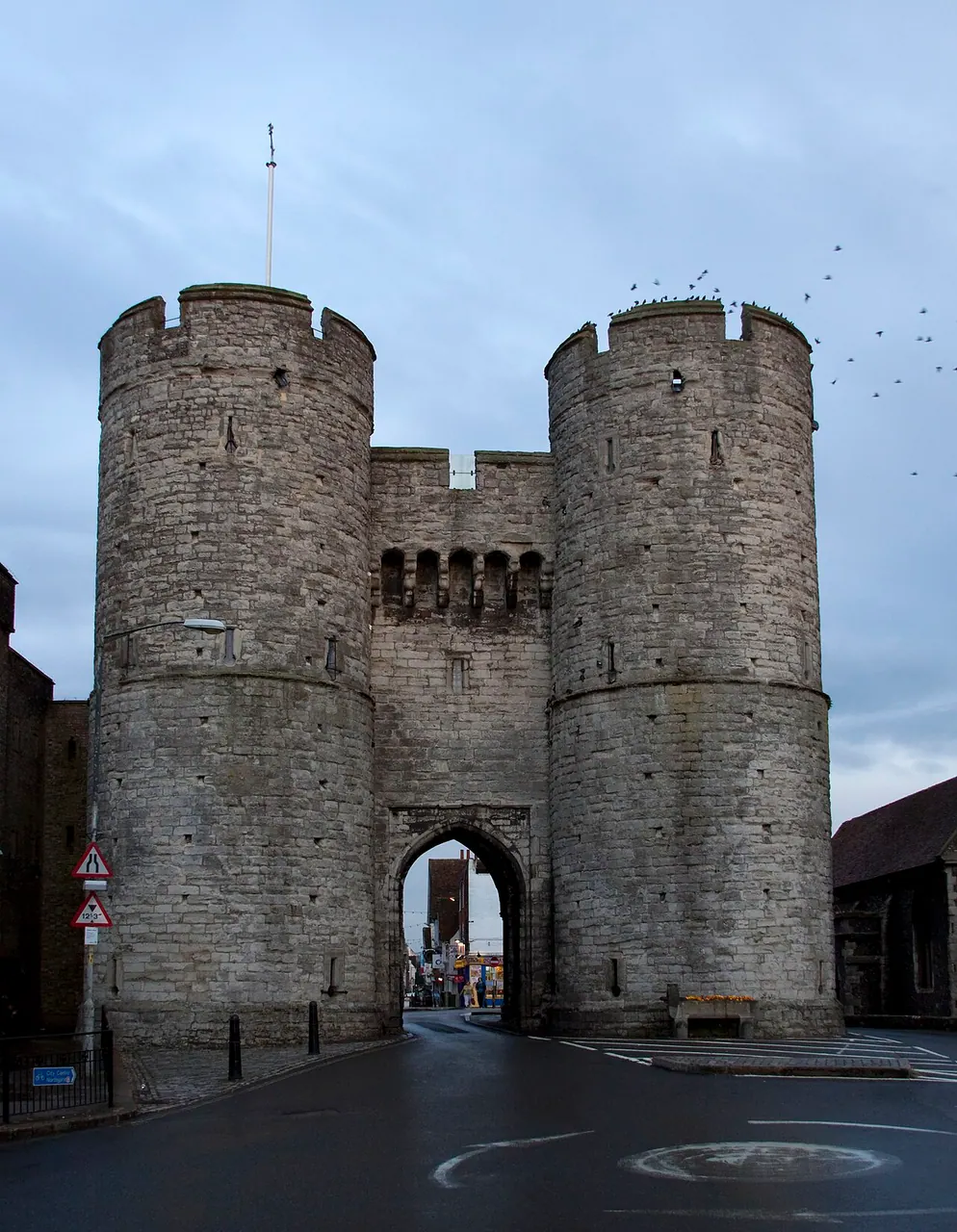 The twin round towers and central archway of Canterbury’s Westgate above the road