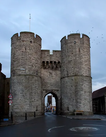 The twin round towers and central archway of Canterbury’s Westgate above the road