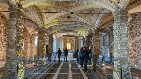 Bone-lined pillars and walls beneath painted vaults in Évora’s Chapel of Bones.