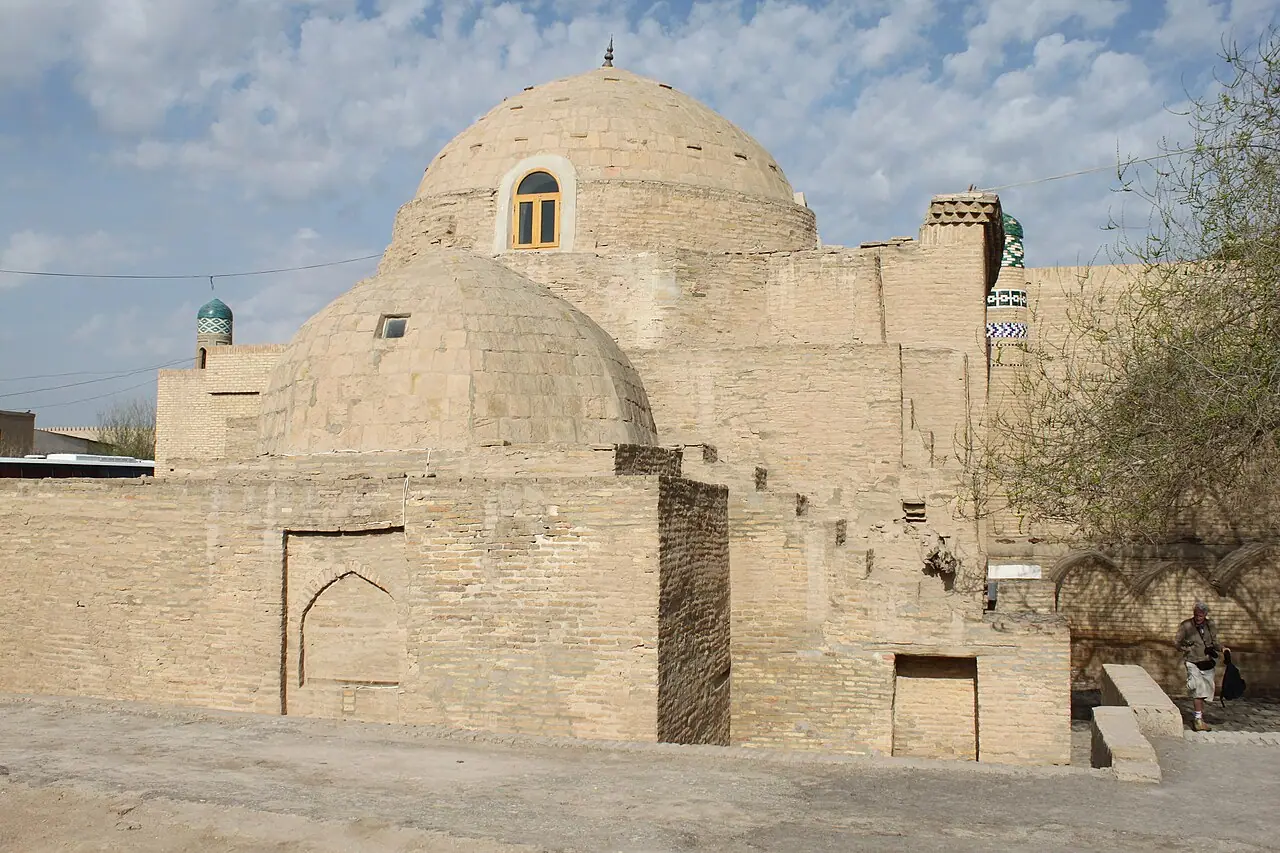 The low brick domes of Sayid Alauddin Mausoleum beside a paved lane in Khiva.