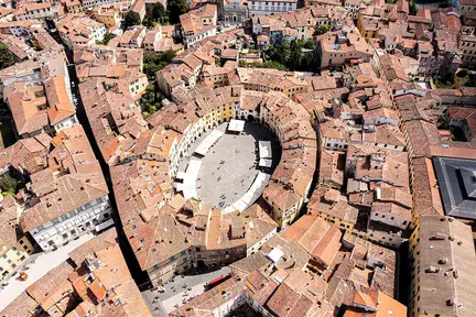 Aerial view of Piazza dell'Anfiteatro, showing an oval opening surrounded by Lucca's roofs