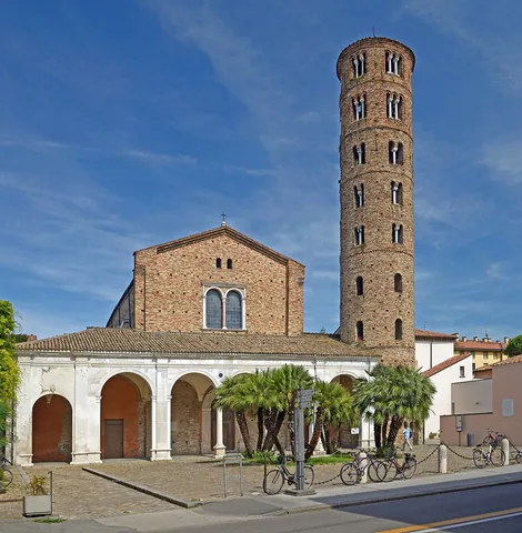 Brick facade, pale portico and cylindrical bell tower of Sant'Apollinare Nuovo in Ravenna