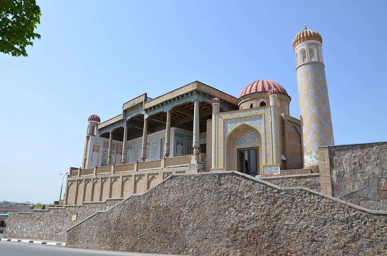Hazrat Khizr Mosque’s columned veranda and patterned minaret rise above a stone retaining wall.