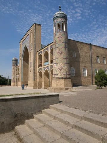 A side view of the entrance portal and brick façade of Tashkent’s Kukeldash Madrasah.
