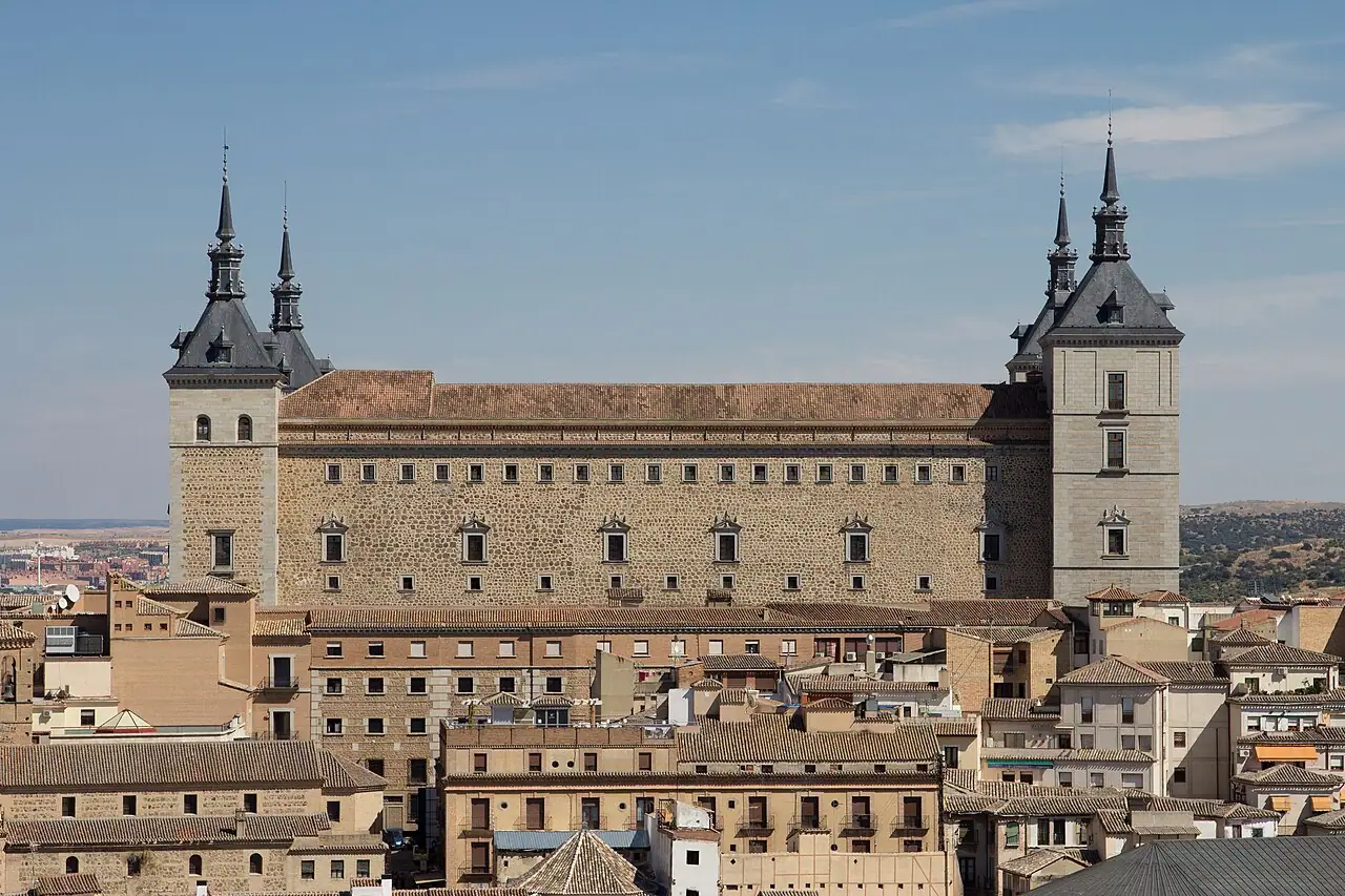 The Alcázar of Toledo’s high rectangular block and corner towers above the city’s rooftops.