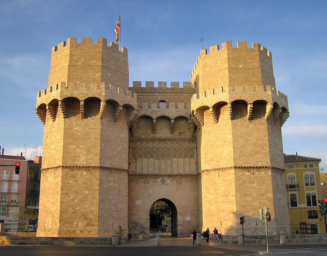 Two polygonal Serranos Towers flanking the gate arch, seen from the outer approach.