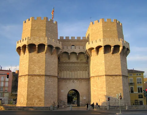 Two polygonal Serranos Towers flanking the gate arch, seen from the outer approach.